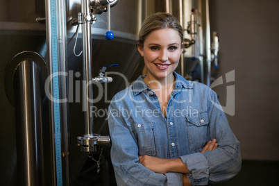 Portrait of smiling worker standing by storage tank