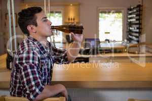 Young man drinking beer at counter