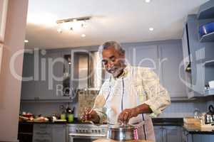 Senior man preparing food in kitchen