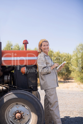 Portrait of happy woman using digital tablet in olive farm