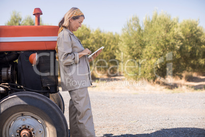 Woman using digital tablet in olive farm