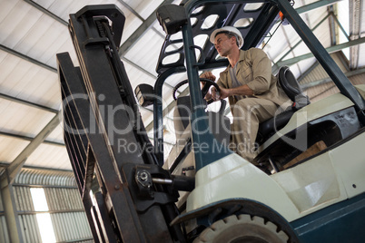 Worker driving forklift