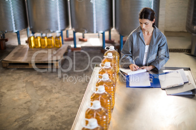 Female worker maintaining record in notepad