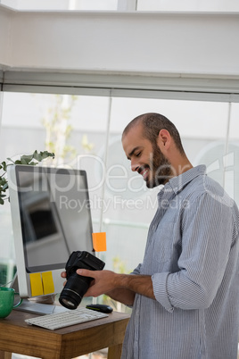 Smiling designer examining camera at studio