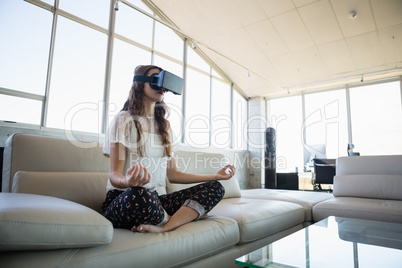Businesswoman mediating while using virtual reality simulator