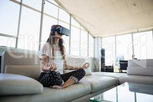 Businesswoman mediating while using virtual reality simulator