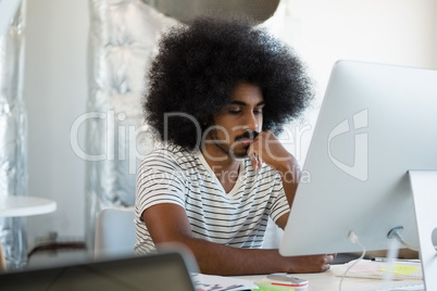 Man with curly hair using computer at office