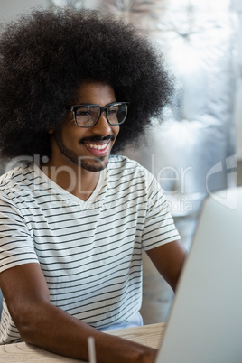 Smiling man using computer at office