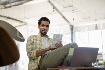 Portrait of young man using tablet in office