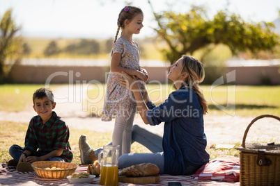 Mother and kids enjoying together on picnic in park