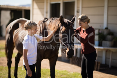 Mother and daughter touching the horse