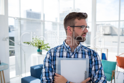 Male executive holding document in the office