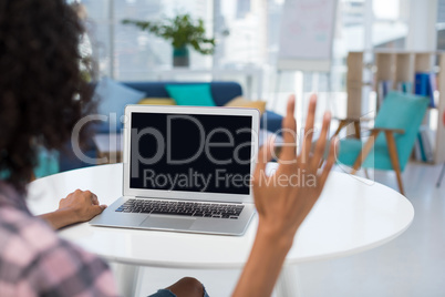 Female executive working on laptop at desk