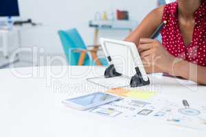 Female graphic designer using graphic tablet at desk