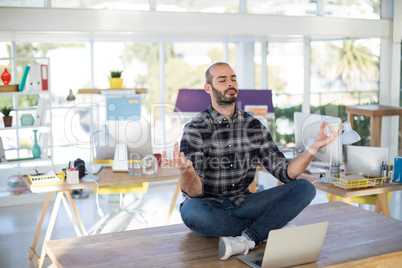 Male executive doing yoga in office