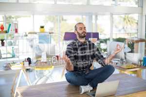 Male executive doing yoga in office