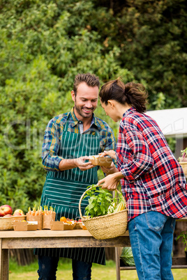 Man selling organic vegetables to woman