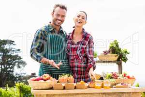 Portrait of happy couple selling organic vegetables