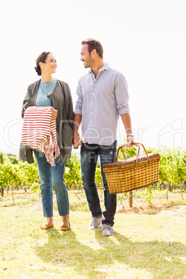 Full length of man with woman holding basket at lawn