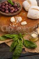 Black olives with herb and garlic by bread on cutting board