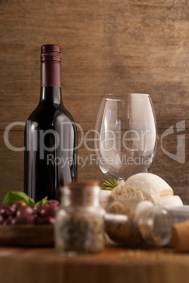 Wineglass by bottle with spice and bread on table