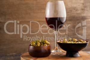 Olives served in bowls by wineglass on table