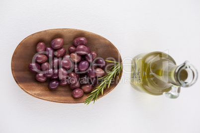 Directly above shot of brown olives in plate by oil in jar