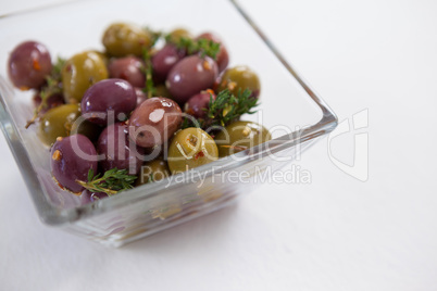 High angle view of olives with herbs served in container
