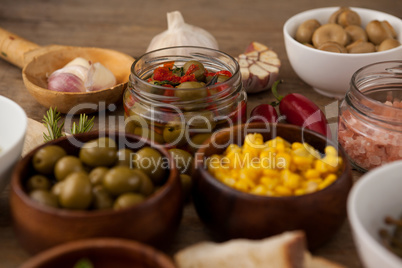 Olives and corns in bowl by spices