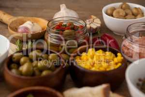 Olives and corns in bowl by spices