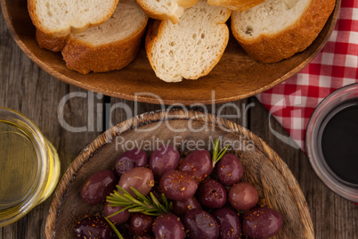 Overhead view of olives and bread with oil in container