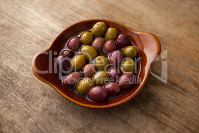 High angle view of olives with oil in wooden container