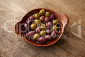 High angle view of olives with oil in wooden container