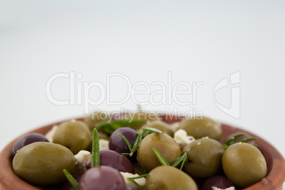 Close up of olives with herb and cheese served in bowl