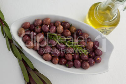 Overhead view of olives and rosemary with oil in jar