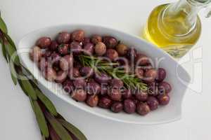 Overhead view of olives and rosemary with oil in jar