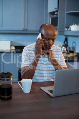 Senior man using laptop at table