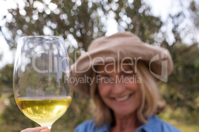 Smiling woman standing with a glass of wine