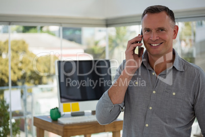 Portrait of smiling designer talking on smart phone