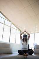 Businesswoman mediating while using virtual reality on sofa