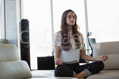 Young businesswoman with eyes closed doing yoga