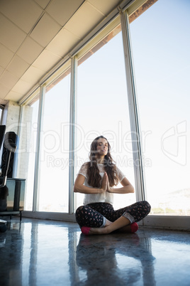 Businesswoman doing yoga on floor