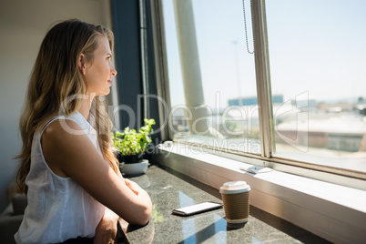 Side view of businesswoman looking through window