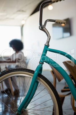 Close-up of bicycle with businessman working in background