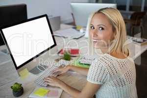 Portrait of woman using computer while working at office