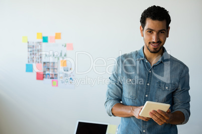 Portrait of man using tablet at office