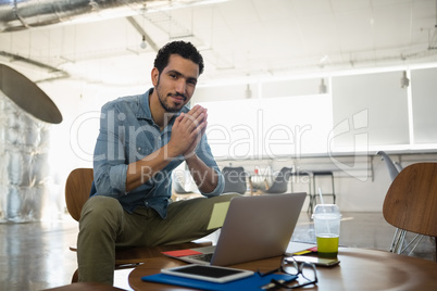 Portrait of man sitting on chair in office