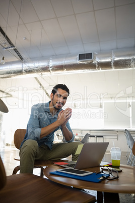 Portrait of smiling man sitting on chair in office