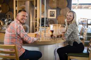 Happy couple having beer at bar counter