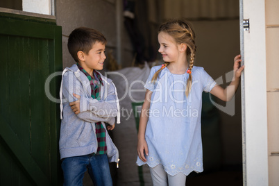 Boy and girl smiling at each other in the stable